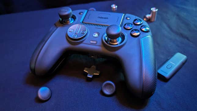 A Nacon Revolution 5 Pro controller sits next to its accessories.